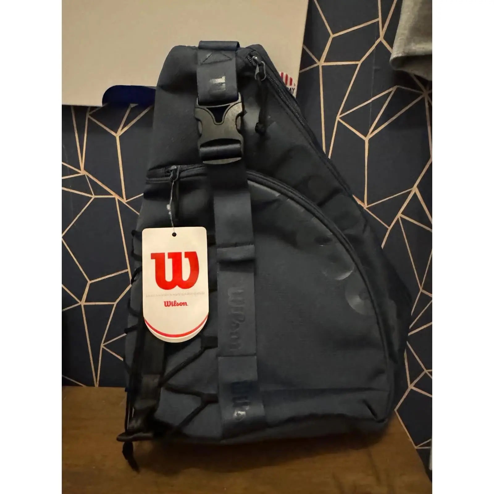 Dark blue Wilson Triangle Pickleball Sling Bag with a top hanging hook and exterior accessory compartment.
