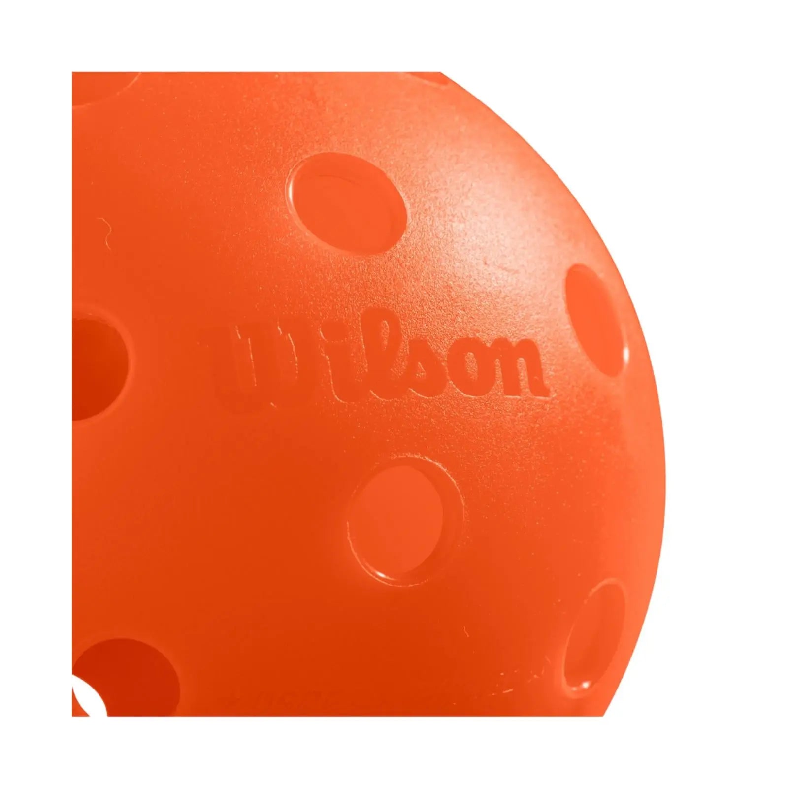 Close-up of a bright orange Wilson Tru 32 indoor pickleball with visible holes and textured finish.