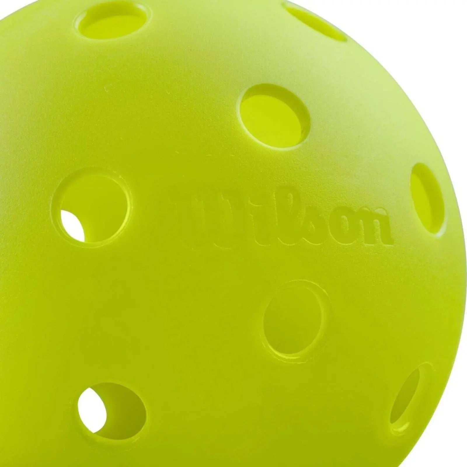 Close-up of a single neon chartreuse Wilson Tru 32 outdoor pickleball with a rough texture and 32 holes.