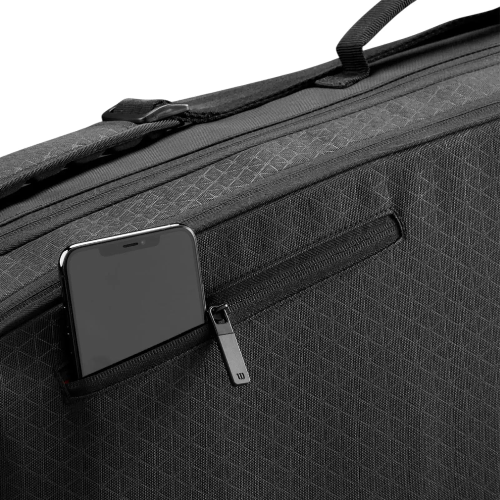 Black Wilson Super Tour Clash v3 tennis bag with subtle triangle pattern and zippered side pocket holding a smartphone.