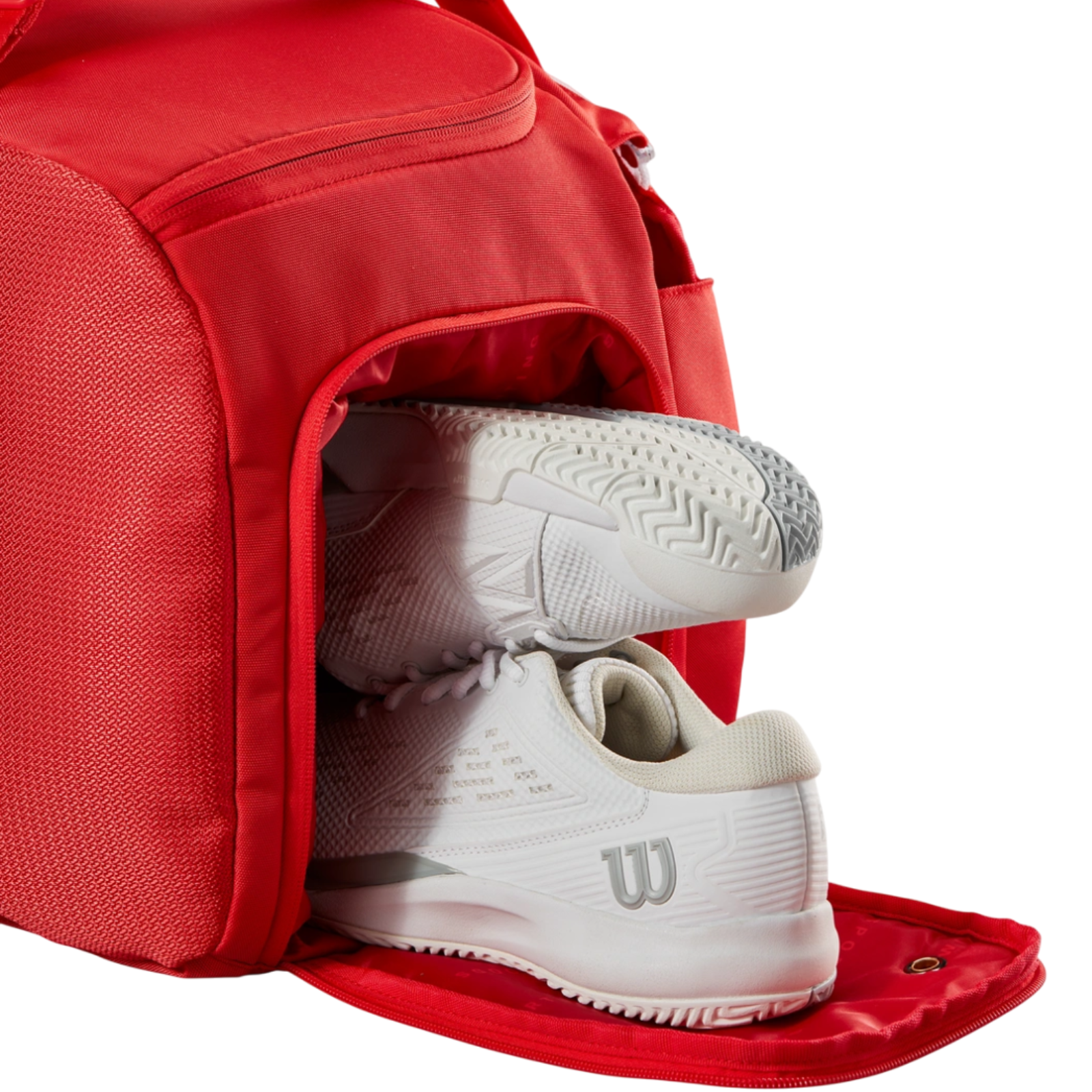 Red Wilson Super Tour Small Duffle tennis bag with white tennis shoes in the dedicated shoe compartment.
