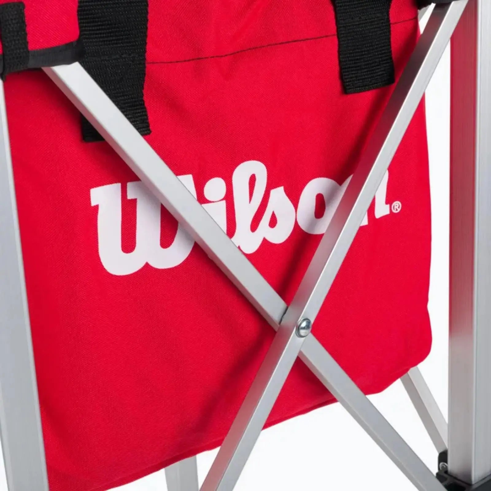 Red Wilson tennis teaching cart with a soft carrying case and silver retractable frame.