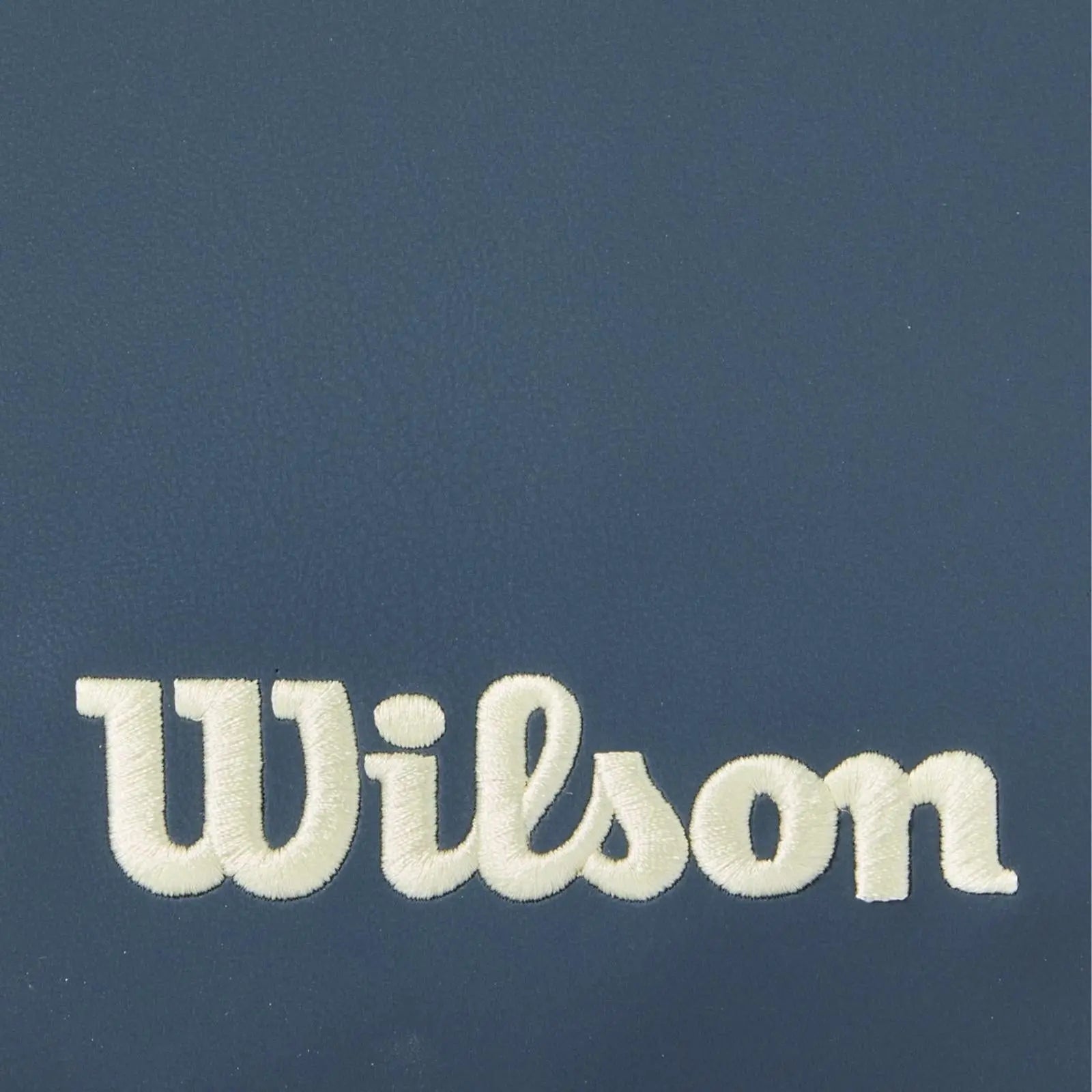 Close-up of a navy blue Wilson pickleball paddle cover with the brand name embroidered in cream.
