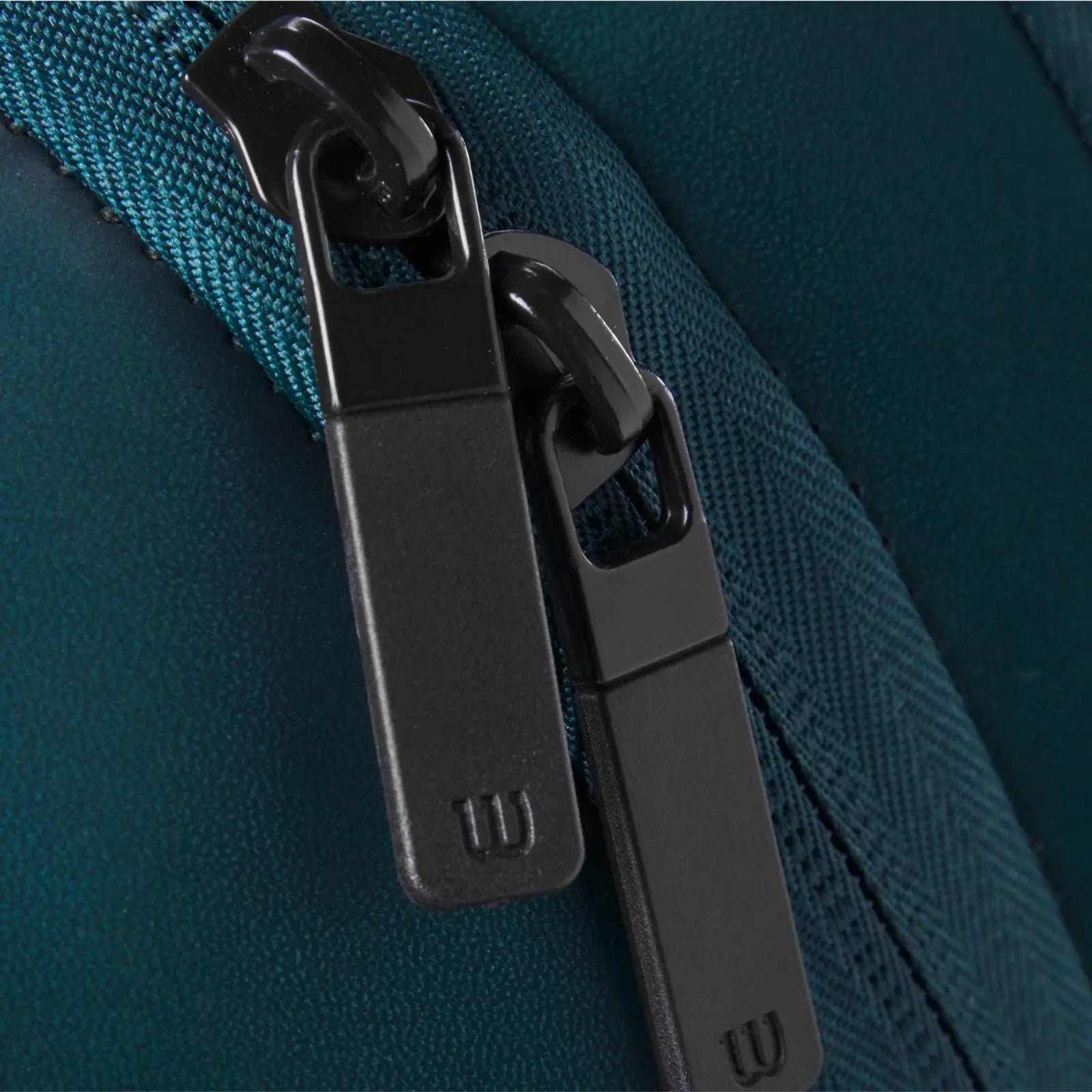 Close-up of a dark green Wilson Blade Super Tour tennis backpack with black locking zippers.