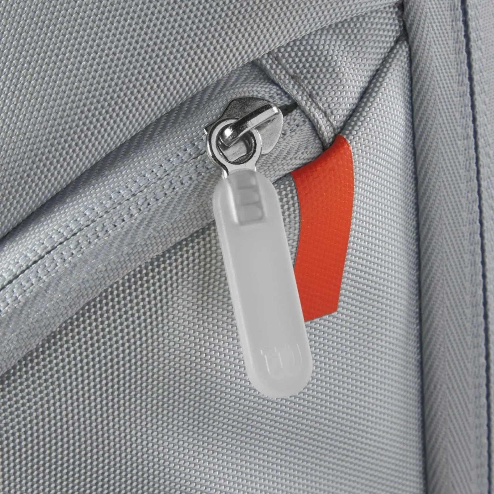 Close-up of a gray Wilson Shift Super Tour Backpack zipper with a white pull and orange accent.