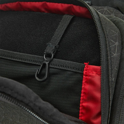 Close-up of the black Wilson Super Tour Clash v3 Tennis Backpack's interior, showing a black hook and red lining.