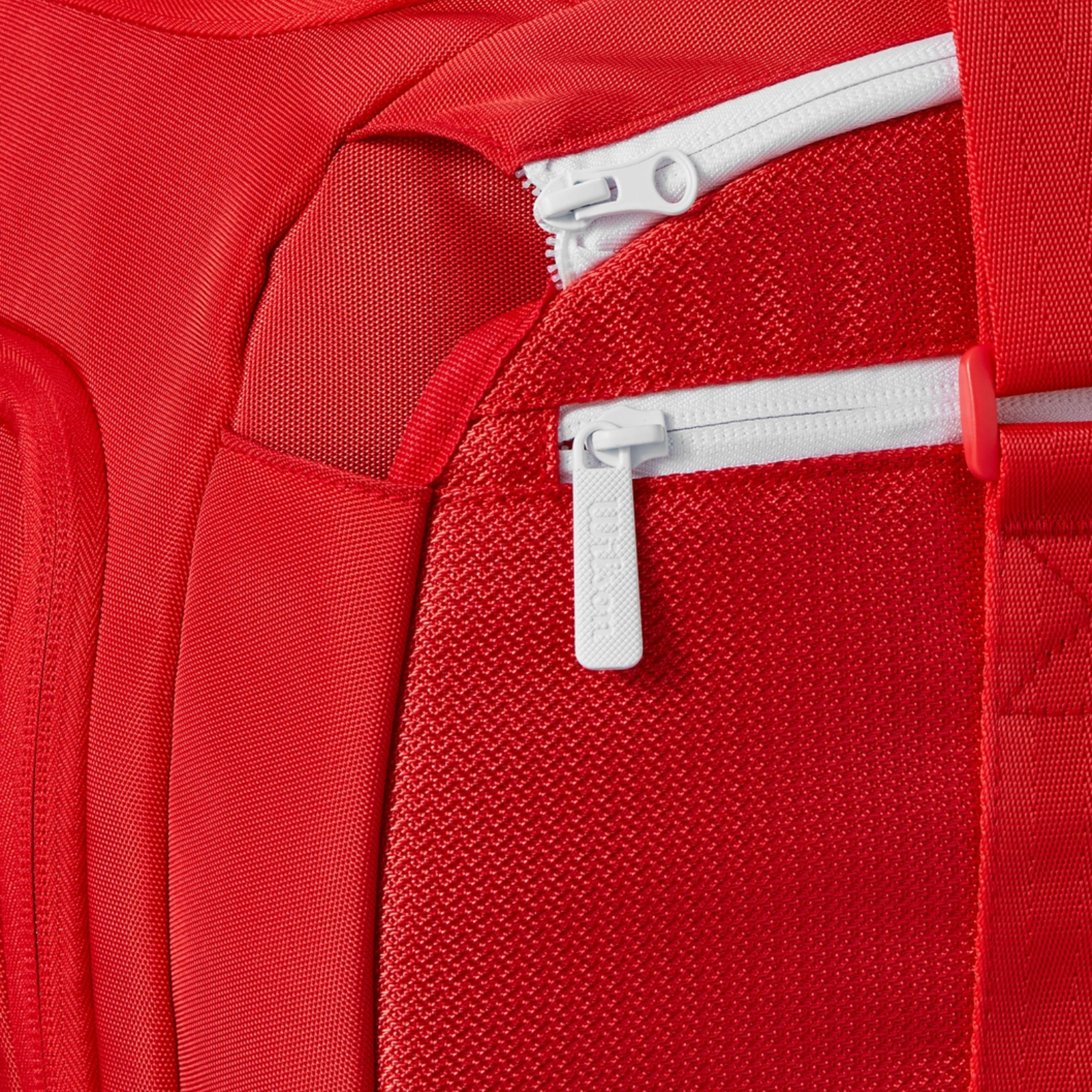 Close-up of a red Wilson Super Tour Small Duffle tennis bag with white zippers and textured fabric.
