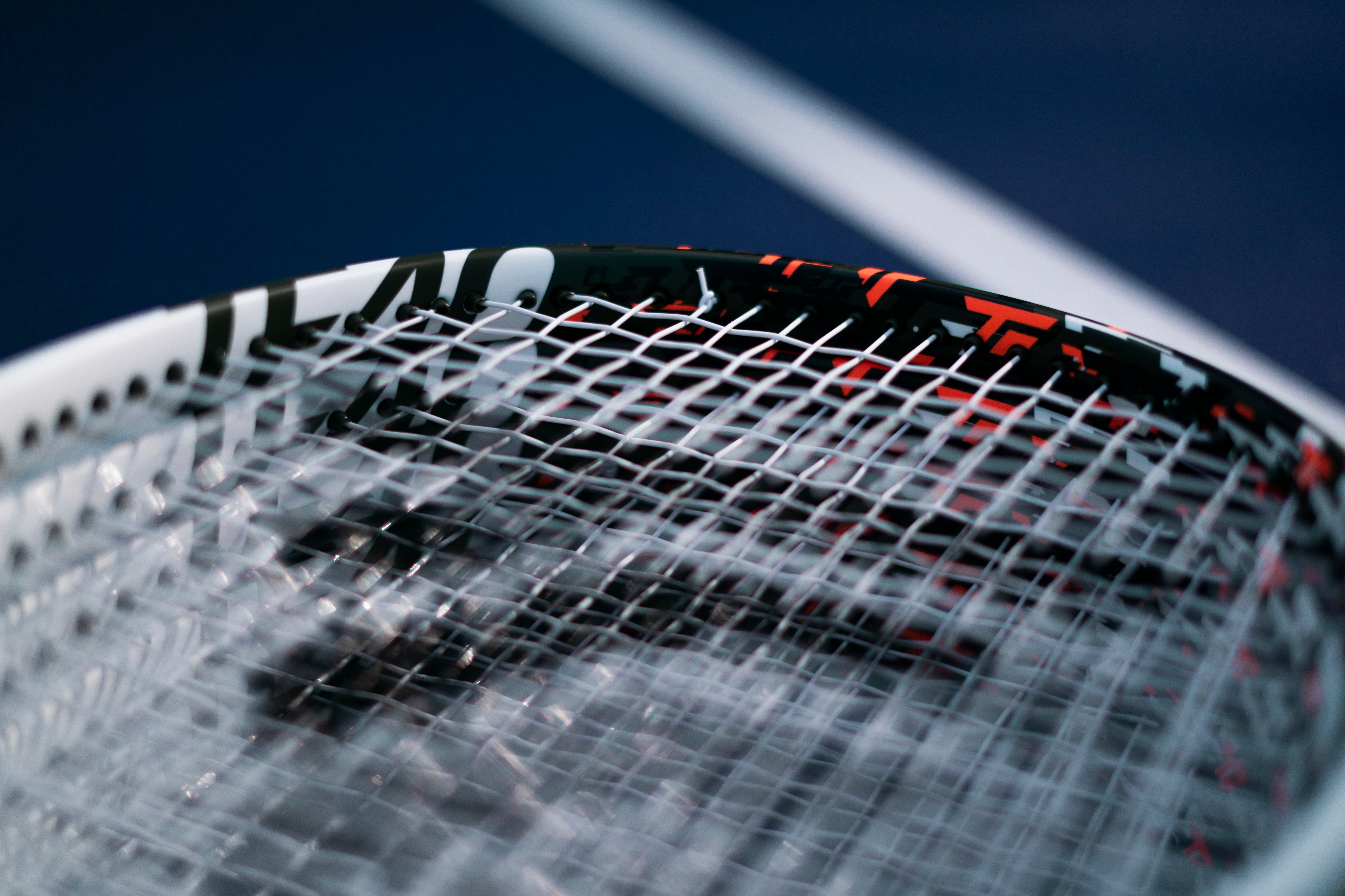 Close-up of a white, black, and red Tecnifibre TF40 305 tennis racquet head with dense 18x20 string pattern.